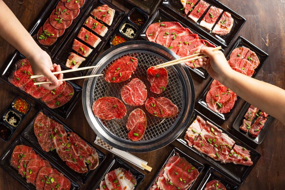 Meats are being cooked on the stove in a Japanese restaurant.