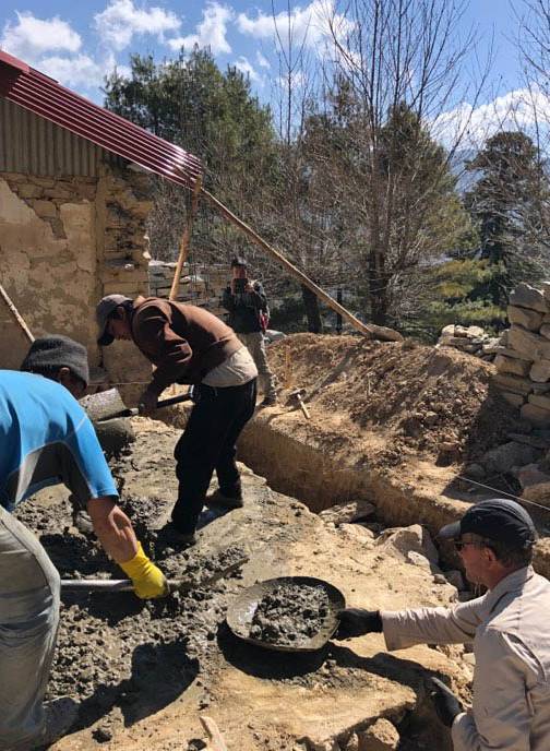 Trekkers collectively helping to build the foundations for new classrooms in Lura village