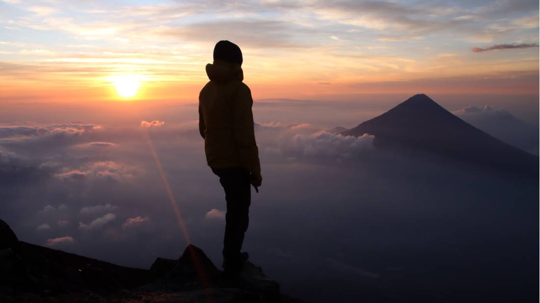 Hiker admiring the view from the summit of Volcan Acatenango